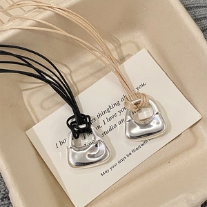 Collana con ciondolo a borsa minimalista con cordini intrecciati in nero e beige