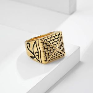 Golden Egyptian Pyramid Ring with Eye of Horus engravings on a white geometric stand