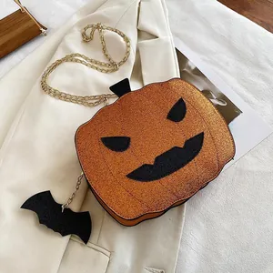 Detail of sequined pumpkin bag with gold chain strap and black bat charm for Halloween
