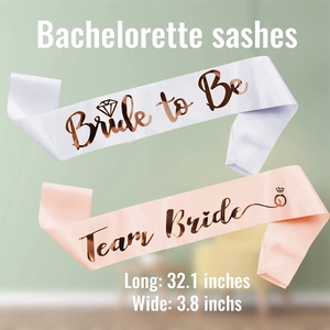 Detailed view of white and pink satin bachelorette sashes with size dimensions