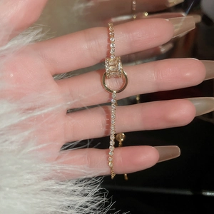 Détail du bracelet doré avec zircones, fermoir cylindre réglable et breloque en anneau