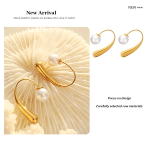 Detail of 18K gold plated titanium earrings with elegant C-shape and white pearl accent