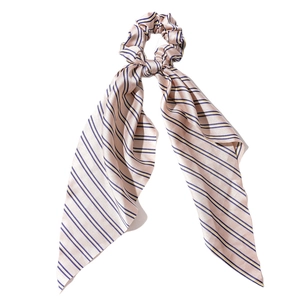 Pink satin scrunchie with blue and yellow stripes and long bow ribbon on white background