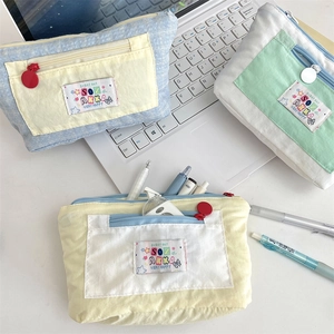 Detailed view of canvas multi-layer pencil cases in blue, green and yellow color schemes