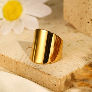 Macro shot of minimalist gold plated wide band ring with a mirror polished finish