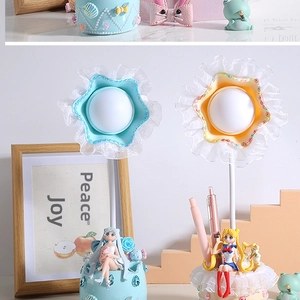 Dettaglio lampada da scrivania fai-da-te con pizzo, portapenne e figure di personaggi anime