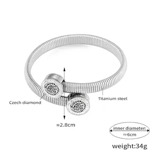 Detail of silver titanium steel spring bracelet with diamond-encrusted round charms