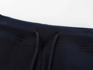 Detail of high-waist yoga shorts featuring navy blue fabric texture and drawstring