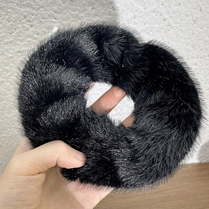 Macro shot of fluffy black plush scrunchie with sparkling silver thread details