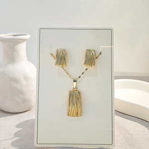 Macro detail of textured rectangular gold necklace and earring set on a display card