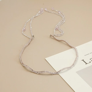 Detail of handmade lavender headband featuring pink bead fringe and wavy metal structure