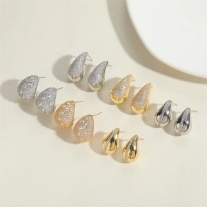 Detailed display of assorted gold and silver teardrop earrings with pavé zircon setting