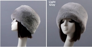 Detailed side view of a light grey plush faux fur winter hat on a white mannequin head