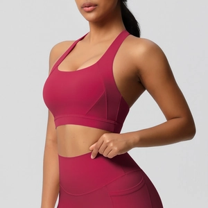 Detail van donkerrode sportbeha en yoga-legging met hoge taille en zijzakken voor fitness
