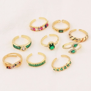 Flat lay of nine adjustable gold rings with vibrant colorful zircon stones set in a display