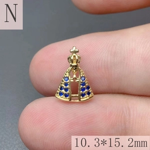 Detailed close-up of a mini 18k gold plated crown pendant with a blue gemstone insert