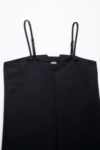 Detalle de hebillas metálicas ajustables y tirantes finos en este top de camisola negro