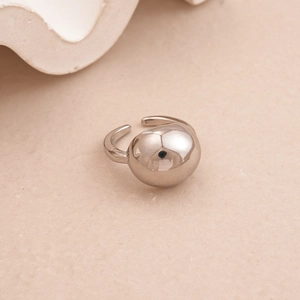 Macro shot of silver sphere open ring with high-polish mirror finish on textured background