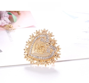 Detailed close-up of baroque gold heart brooch featuring crystal rhinestones and starburst edges
