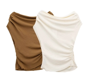 Detailed view of two-tone asymmetrical off-shoulder tops in tan and cream textured fabric