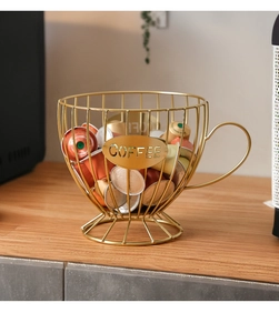 Detail of a golden cup-shaped metal coffee pod holder with decorative 'COFFEE' plaque