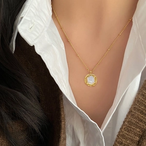 Elegant gold titanium steel necklace with irregular round white shell pendant on model