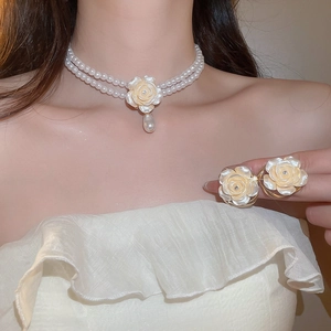 Détail d'un ensemble élégant collier de perles double couche et boucles d'oreilles fleurs