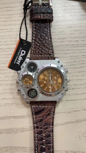 Macro view of Oulm oversized quartz watch showing dual time zones and compass dial