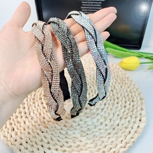 Braided rhinestone headbands in champagne gold, dark grey, and silver glitter finishes