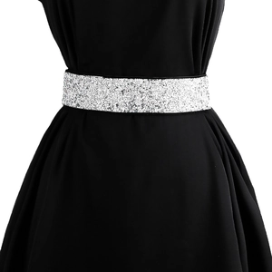 Close-up of sparkling silver rhinestone wide elastic belt worn over a black dress
