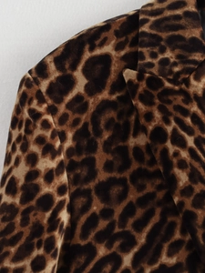 Detailed macro view of leopard print blazer lapel and shoulder fabric texture