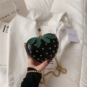 Cute black strawberry shaped crossbody bag with gold studs and a metallic chain strap