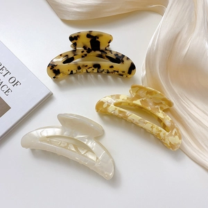 Three acetate hollow semi-circle hair claws in amber, marble, and pearlescent white