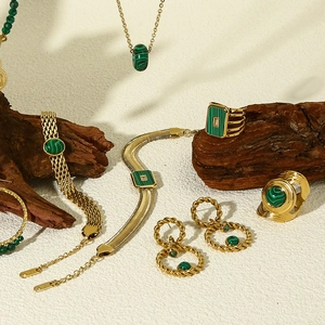 Artistic detail of 18k gold jewelry set featuring natural green malachite gemstones