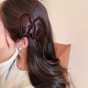 Detail view of deep brown flocked hair clips with soft velvet texture on a model