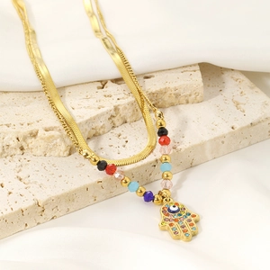 Detailed shot of double-layered gold Hamsa Hand necklace with colorful rhinestones