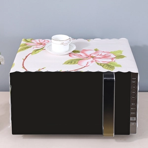 Detail of pink magnolia pattern on linen microwave dust cover with laser-cut wavy edges