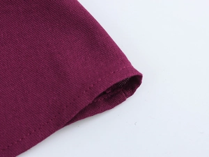 Détail du revers de robe en coton-lin rouge pourpre avec texture de tissu et coutures
