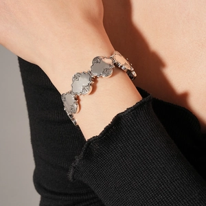 Gros plan d'un bracelet en argent vintage avec des gravures florales sur des maillons