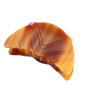 Polished amber tortoise shell acetate hair claw clip with a sleek semi-circular design