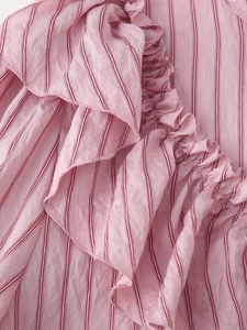 Macro shot of pink striped fabric with ruffled decorative details on a women's shirt