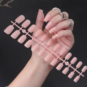 Macro shot of matte nude pink square false nails set with 24 pieces on plastic runner