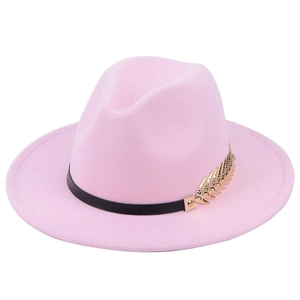 Detail of pink wool fedora hat featuring black ribbon and golden leaf metal ornament
