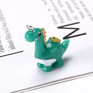 Handmade green resin dinosaur charm with orange spikes and metal hanging ring