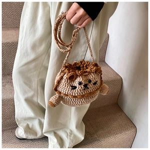 Detail of hand-knitted lion crossbody bag with 3D yarn texture and cute animal design