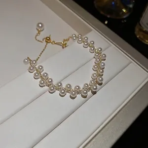 Élégant bracelet double rang de perles avec chaîne dorée et fermoir réglable sur boîte