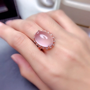 Rose gold ring with large oval pink stone and micro-diamond pavé on a model hand