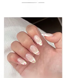 Close-up of French almond press-on nails with white lace edges and pink roses