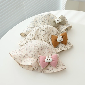 Detailed close-up of baby sun hats with floral patterns and cute 3D bunny bow accents