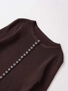 Detail view of coffee brown ribbed knit top featuring decorative buttons and crew neckline